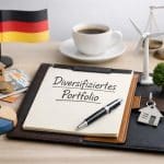 Symbolische Darstellung von Investitionen und Finanzplanung: Ein Notizbuch mit der Aufschrift ‚Diversifiziertes Portfolio‘ liegt auf einem Schreibtisch, umgeben von Euro-Banknoten, Münzen, einem Modellhaus, einem Kreisdiagramm, einem Windrad, einem Schlüssel mit Haussymbol sowie einer Kaffeetasse. Im Hintergrund stehen eine Waage und eine kleine deutsche Flagge. Das Bild vermittelt die Planung eines diversifizierten Portfolios in Deutschland bei hohen Zinsniveaus und strategischen Investitionen.